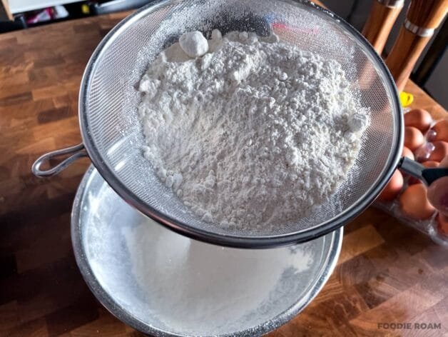 Sifting self-raising flour and salt into a mixing bowl to aerate and remove lumps.