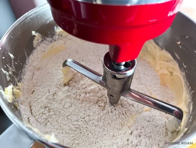 Sifted flour and salt added to the creamed butter and sugar mixture in a stand mixer.