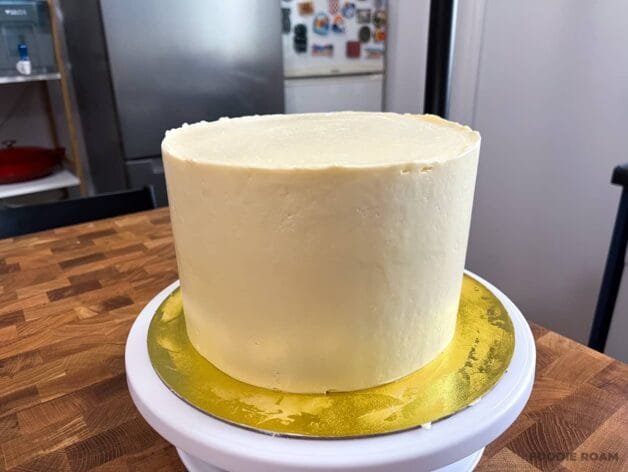 Smooth final layer of almond mascarpone buttercream on a cake.