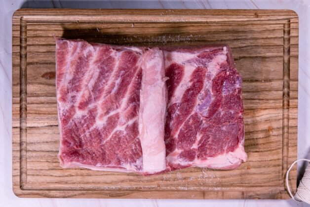 Seasoned pork belly with an additional piece of meat placed in the center before rolling.