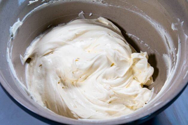 A light and airy whipped cream and cream cheese mixture in a mixing bowl.