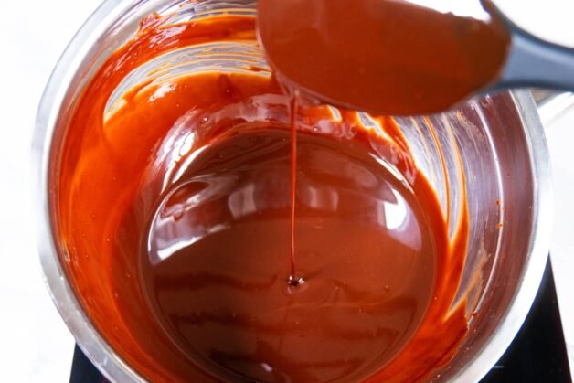 Smooth melted chocolate and butter in a saucepan, showing a glossy texture ideal for dessert preparation.