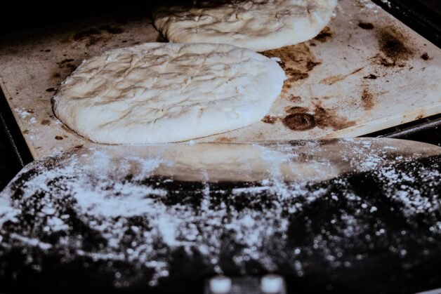 Flatbreads baking on a preheated pizza stone in the oven.