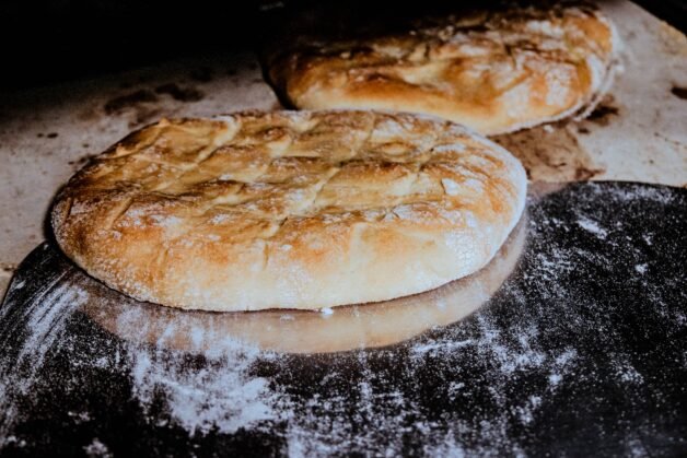 Golden-brown flatbreads freshly baked on a pizza stone.