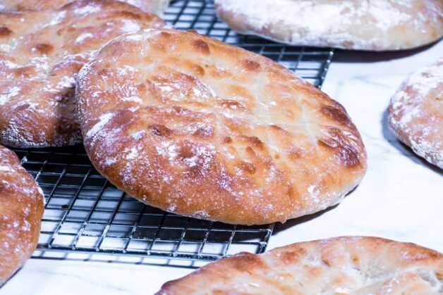 Golden-brown traditional flatbreads cooling on a wire rack.